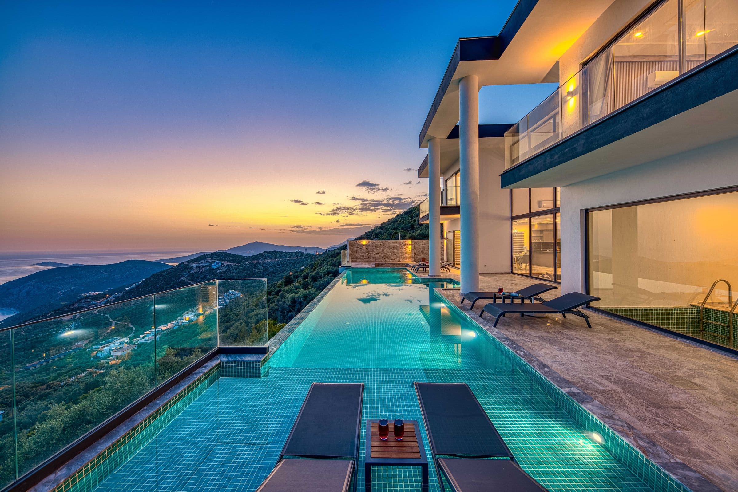 Villa contemporánea con piscina infinita frente al mar en la hora dorada